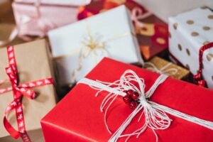 A pile of presents with red and white wrapping paper, decorated with festive bows.