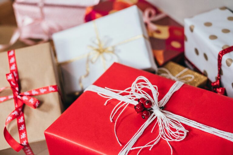 A pile of presents with red and white wrapping paper, decorated with festive bows.