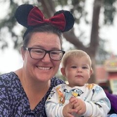 Cynthia Calhoon wearing Mickey ears and holding a baby